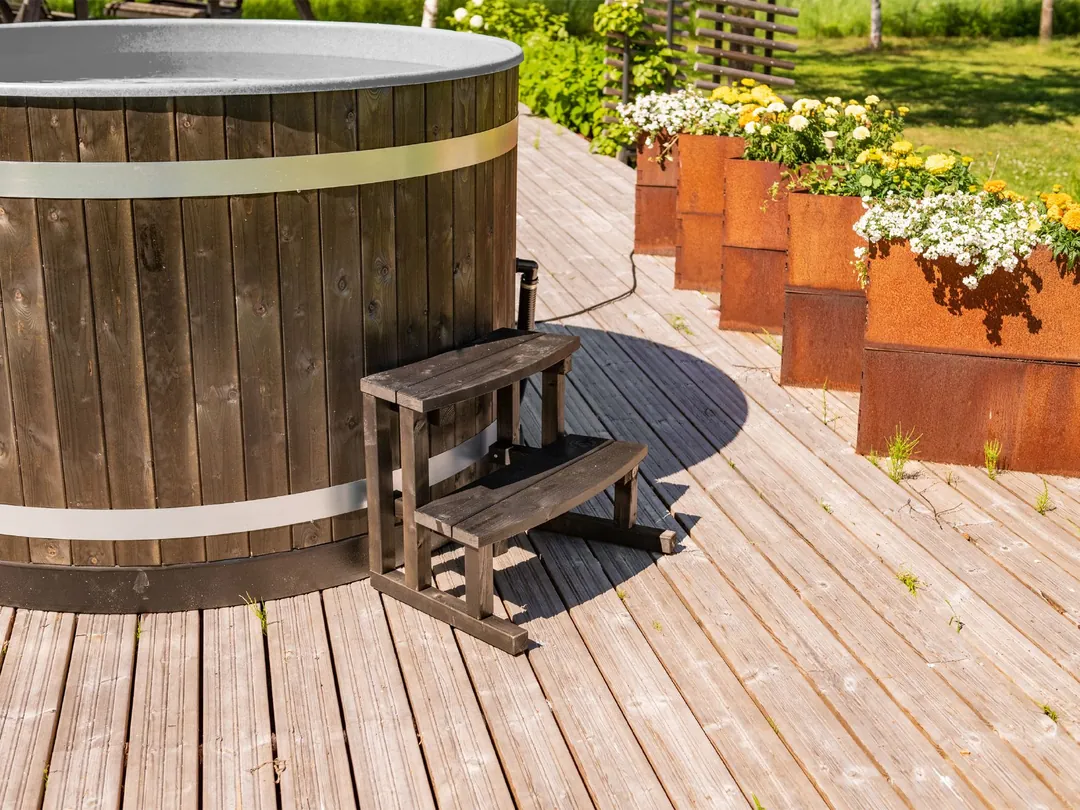 Bain nordique Harvia Original Breezy M en épicéa teinté noir sur une terrasse en bois, marches d’accès