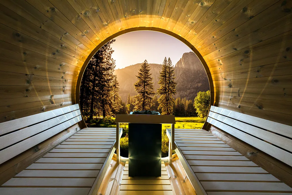 Intérieur d’un sauna tonneau Harvia Kaski View : bancs face à une grande fenêtre ronde sur un paysage