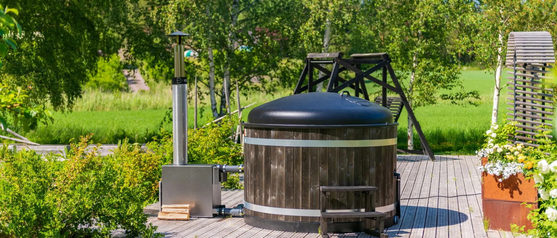 Bain nordique Harvia couvercle fermé sur une terrasse au milieu d’un jardin