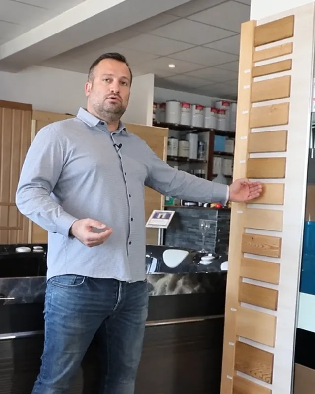 Julien Bonhomme au showroom de Gigean, devant un nuancier de bois de sauna