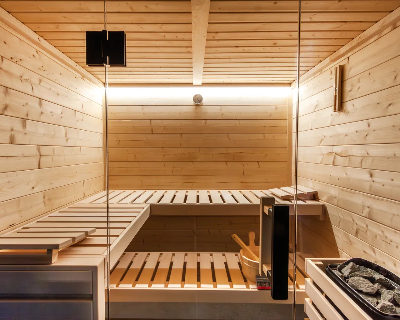 Intérieur d’une cabine de sauna Harvia Family : bancs en tilleul, poêle et éclairage LED