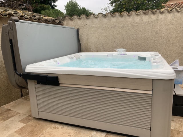 Spa 6 personnes en eau sur une terrasse avec sa couverture et son lève-couverture