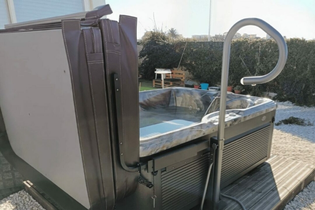 Spa Célio 3 places installé sur une terrasse à Leucate avec son couvercle relevé pour une utilisation facile