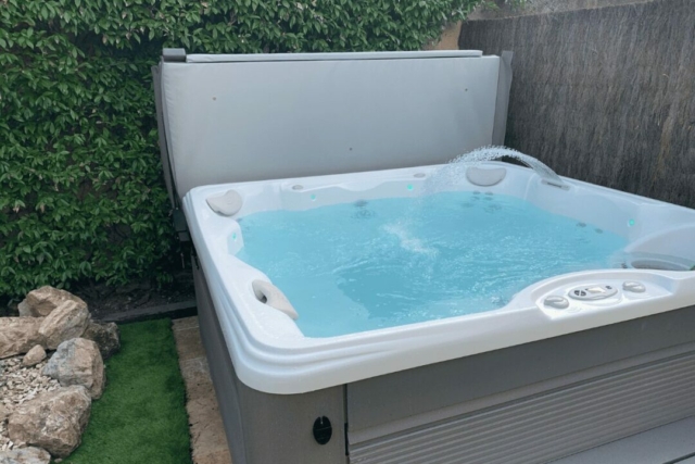 Installation d’un spa haut de gamme dans un jardin privé avec mise en eau.